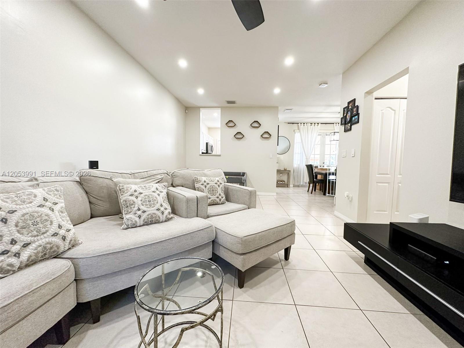 A living room features a light gray sectional sofa, tile flooring, and recessed lighting — 130 Riverwalk Cir # 130, Sunrise FL 33326, SUNRISE, FL