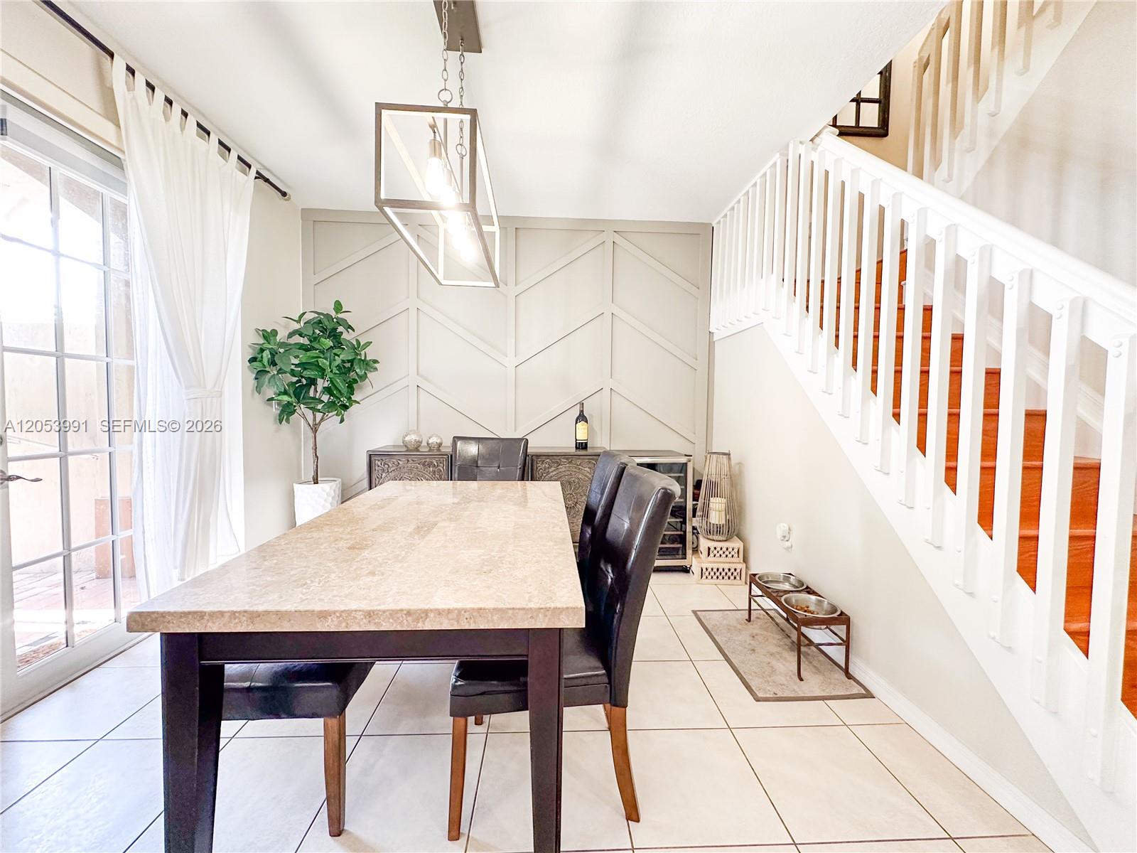 A dining room features a stone-topped table, a chevron-patterned accent wall, and a staircase — 130 Riverwalk Cir # 130, Sunrise FL 33326, SUNRISE, FL