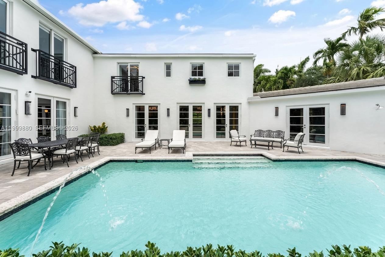 A white two-story house with a swimming pool and patio furniture in the backyard — 2887 Pine Tree Dr, Miami Beach FL 33140, MIAMI BEACH, FL