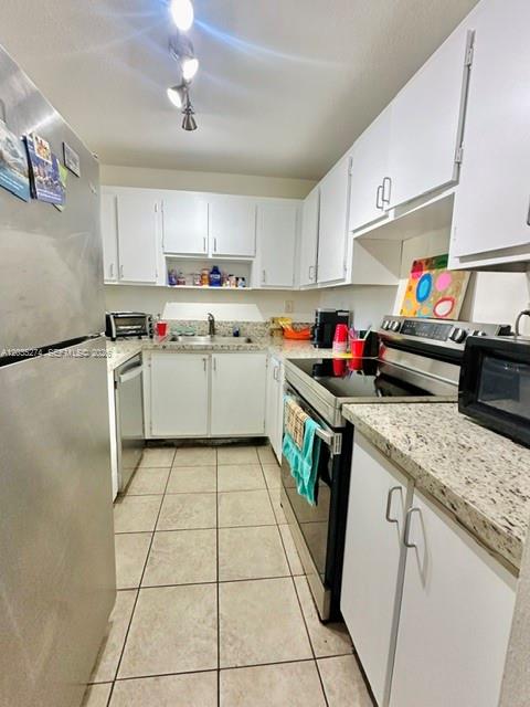 A kitchen features white cabinets, granite countertops, stainless steel appliances, and light-colored floor tiles — 9301 SW 92nd Ave # A407, Miami FL 33176, MIAMI, FL