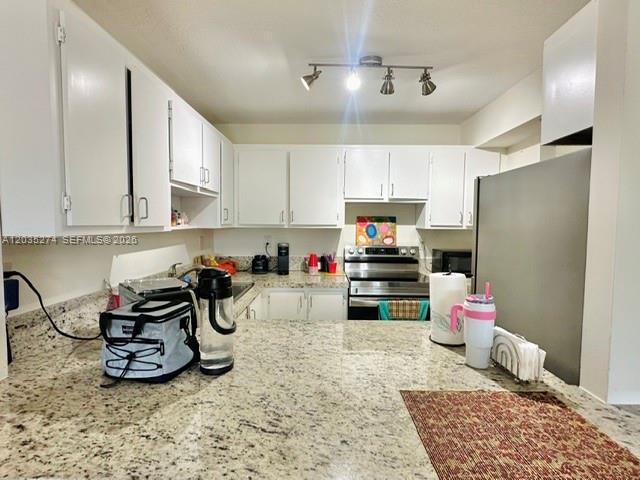 A kitchen features white cabinets, granite countertops, and stainless steel appliances — 9301 SW 92nd Ave # A407, Miami FL 33176, MIAMI, FL