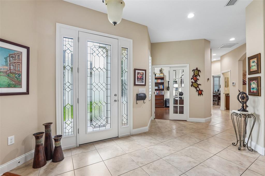 An entryway with tile flooring, a glass-paneled front door, and a view into an office — 2849 DEVONOAK BOULEVARD, LAND O LAKES, FL