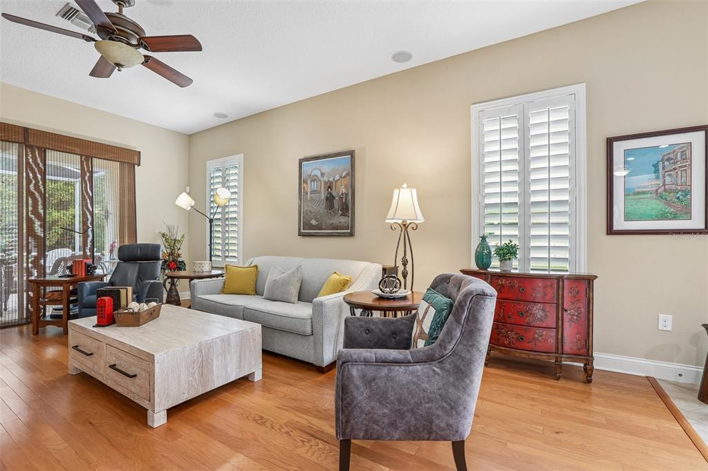 A living room features a light gray sofa, a coffee table, and hardwood flooring — 2849 DEVONOAK BOULEVARD, LAND O LAKES, FL