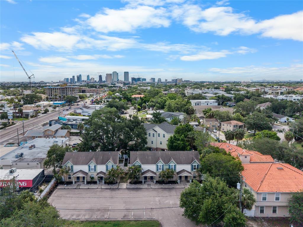 An aerial view shows a multi-unit townhouse complex with a parking lot and city skyline — 106 S HABANA AVENUE UNIT 7, TAMPA, FL