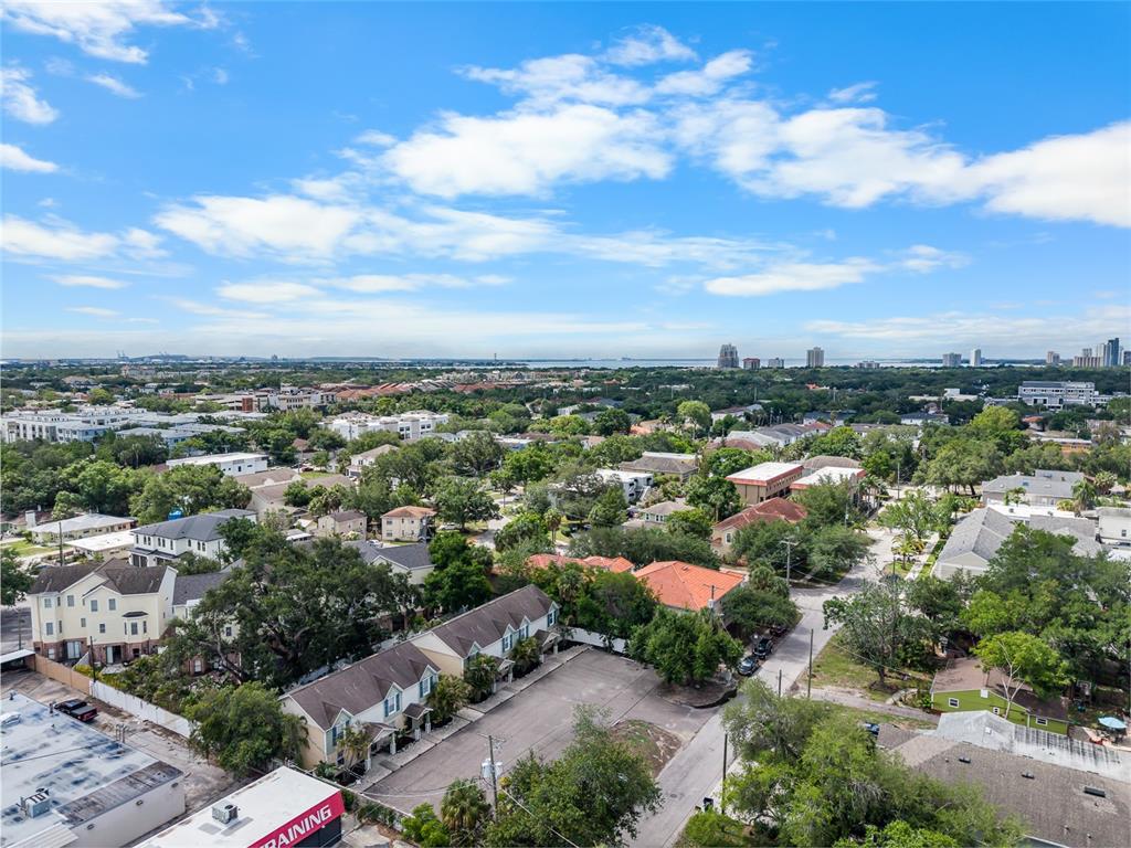 An aerial view shows a residential neighborhood with townhouses, trees, and a distant city skyline — 106 S HABANA AVENUE UNIT 7, TAMPA, FL