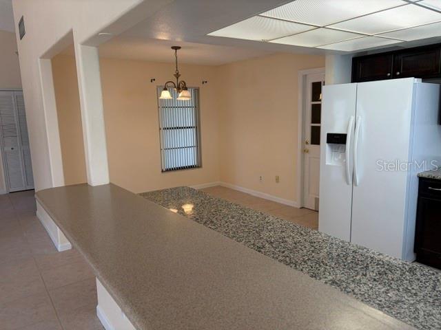 A kitchen features a granite breakfast bar, a white refrigerator, and an adjacent dining area — 1922 DOCKSIDE DRIVE, VALRICO, FL
