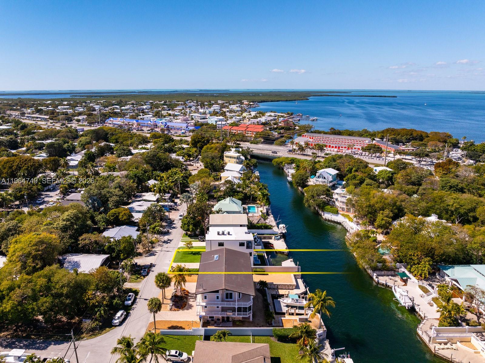 An aerial view shows a waterfront property with a canal and boat dock — 16 Bass Ave, Key Largo FL 33037, KEY LARGO, FL
