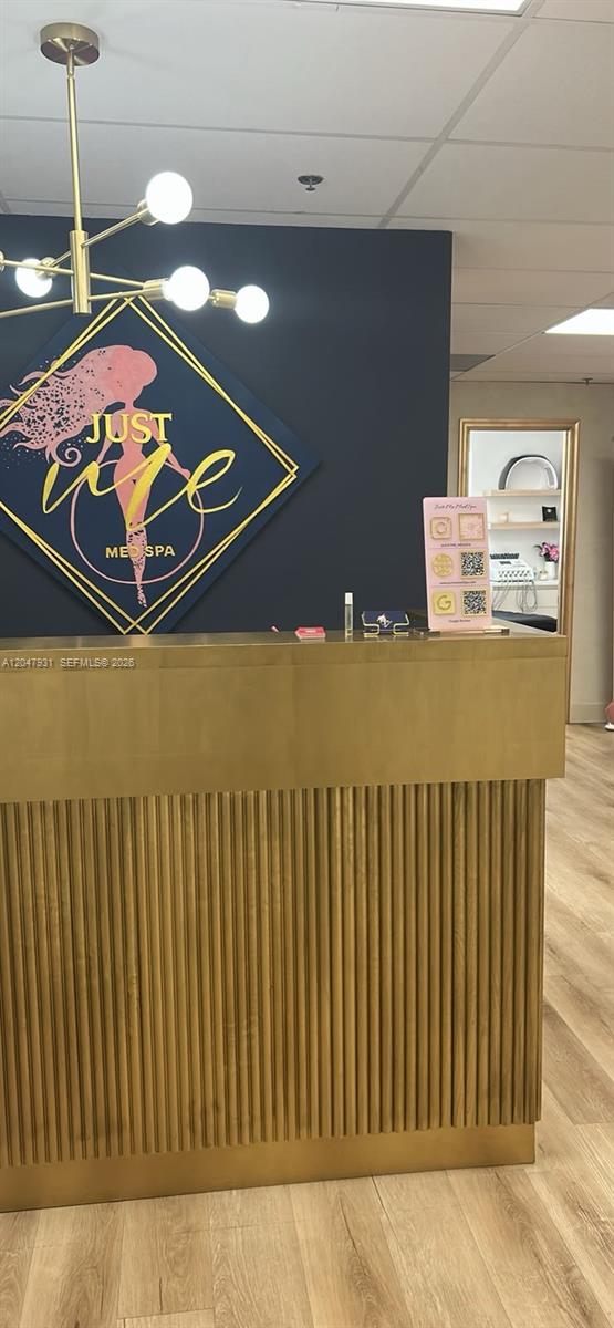 A gold-toned reception desk sits in front of a dark wall with a spa logo — 1730 Main St # 210, Weston FL 33326, WESTON, FL