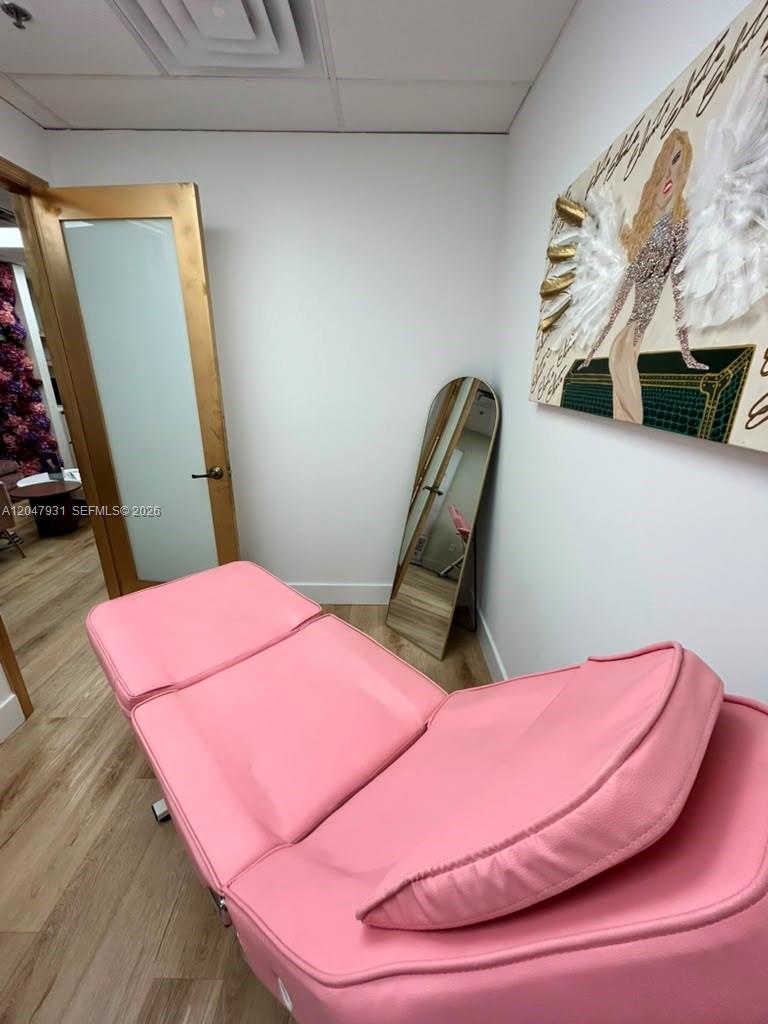 A pink treatment bed sits in a small room with a mirror and wall art — 1730 Main St # 210, Weston FL 33326, WESTON, FL