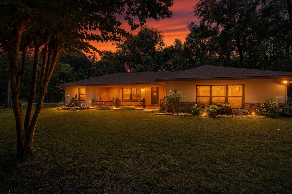 A single-story house with a gravel driveway sits in a wooded lot — 18451 NW 141ST AVENUE, WILLISTON, FL