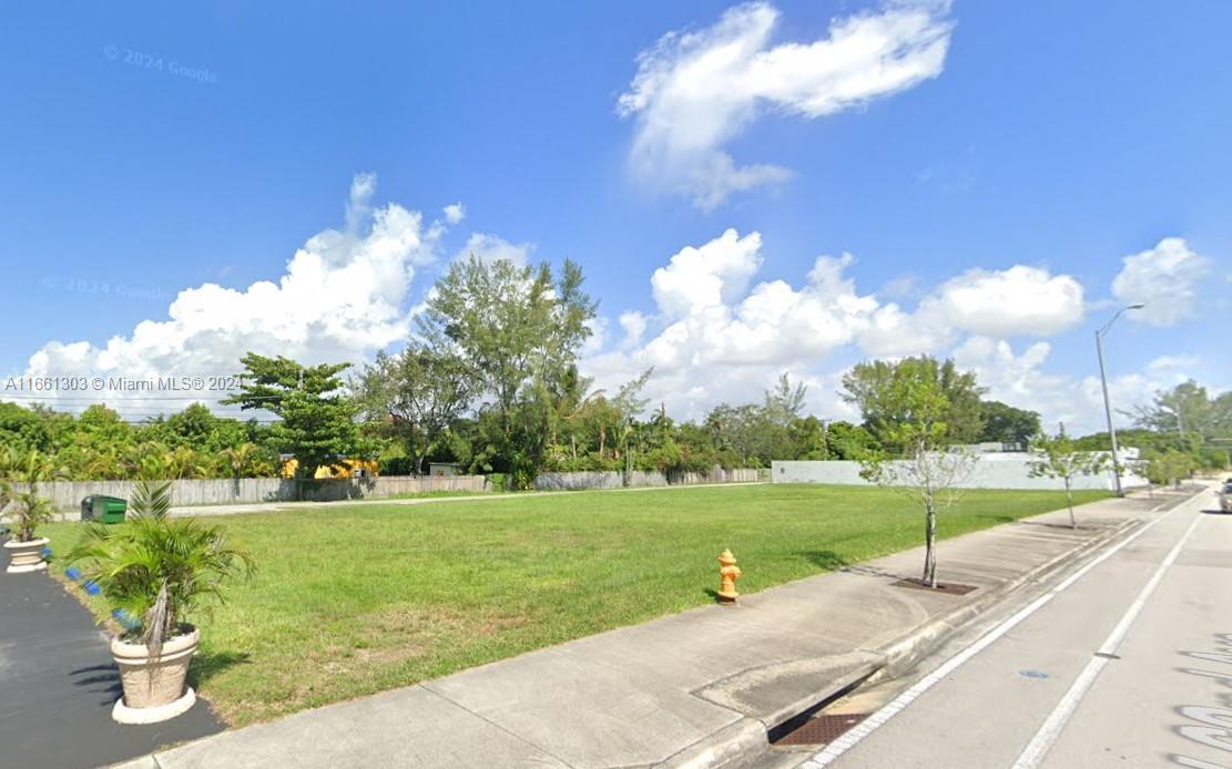 A vacant, grassy rectangular lot is bordered by a sidewalk, a fire hydrant, and trees — 62 Ave SW 66 St, South Miami FL 33143, SOUTH MIAMI, FL