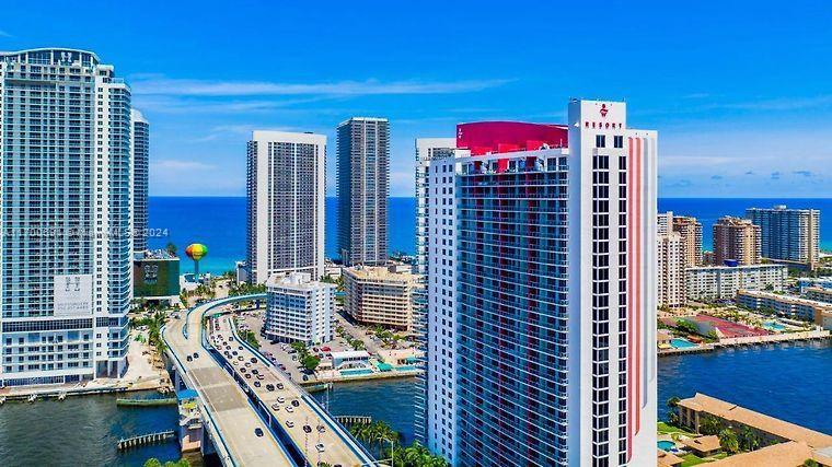 An aerial view shows high-rise buildings, a bridge with traffic, and a coastal waterway — 2602 E Hallandale Beach Blvd # R508, Hallandale Beach FL 33009, HALLANDALE BEACH, FL