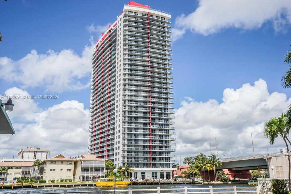 A tall residential high-rise building stands along a canal with a bridge nearby — 2602 E Hallandale Beach Blvd # R508, Hallandale Beach FL 33009, HALLANDALE BEACH, FL