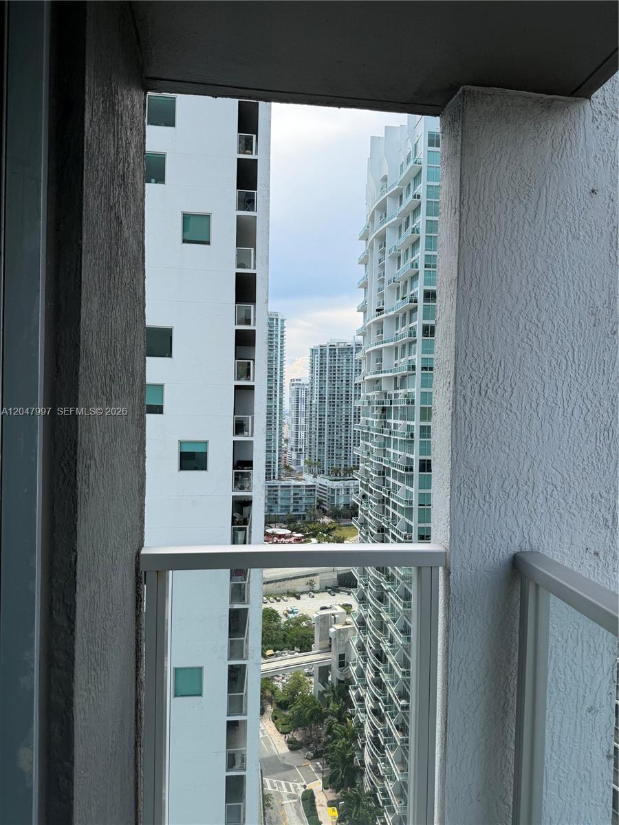 A view of urban high-rise buildings seen from a balcony with a glass railing — 500 Brickell Ave # 2907, Miami FL 33131, MIAMI, FL
