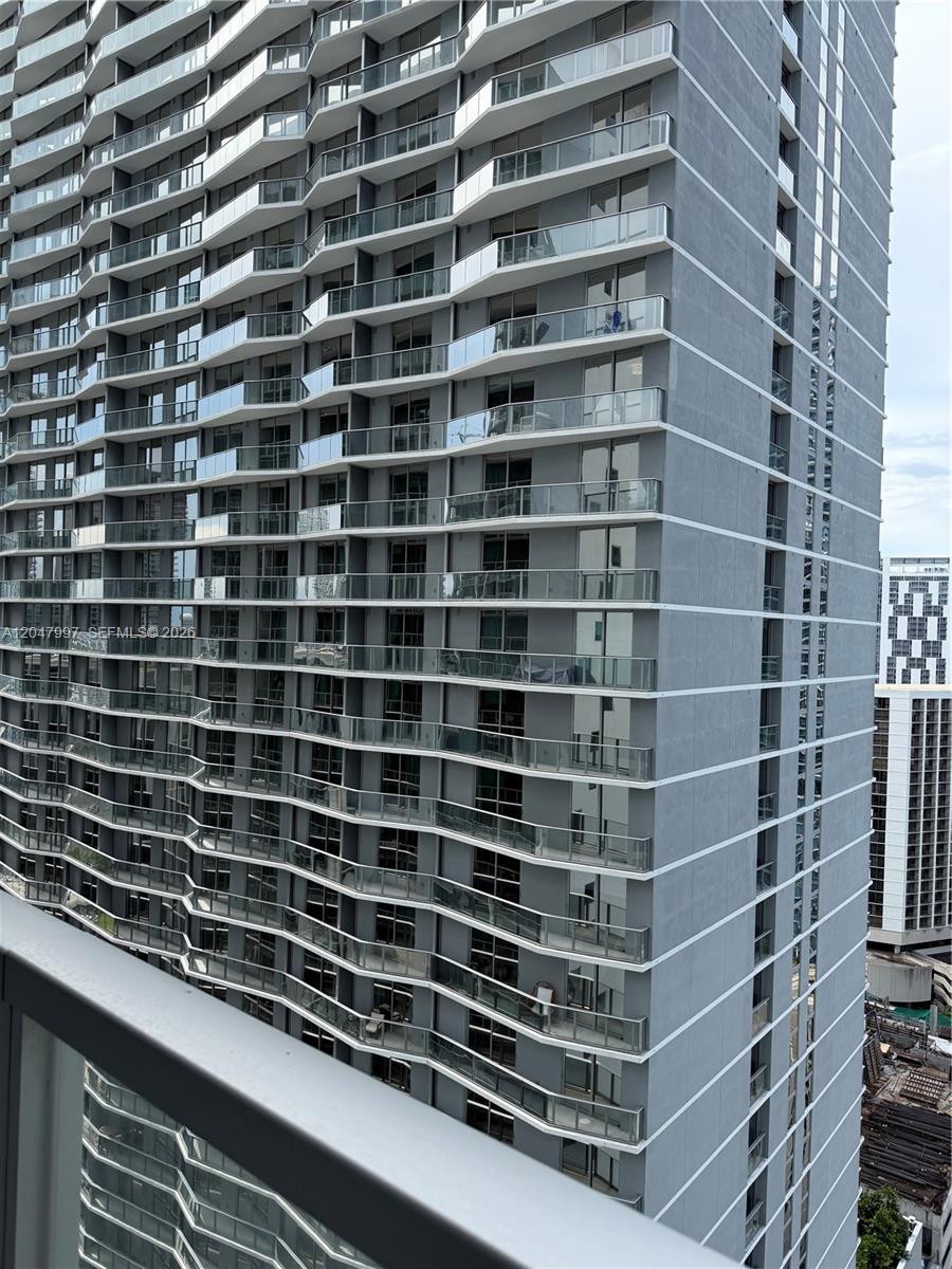 A view of a high-rise residential building featuring stacked balconies with glass railings — 500 Brickell Ave # 2907, Miami FL 33131, MIAMI, FL