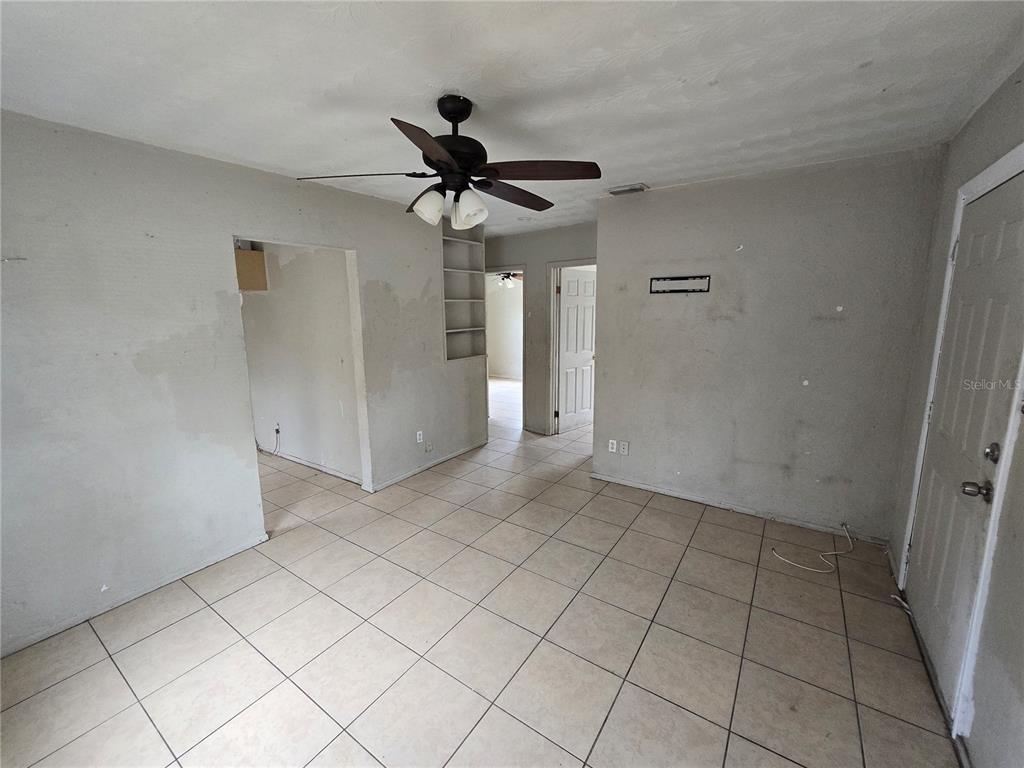 An interior view of a room with tiled floors, a ceiling fan, and open doorways — 1511 27TH STREET S, ST PETERSBURG, FL