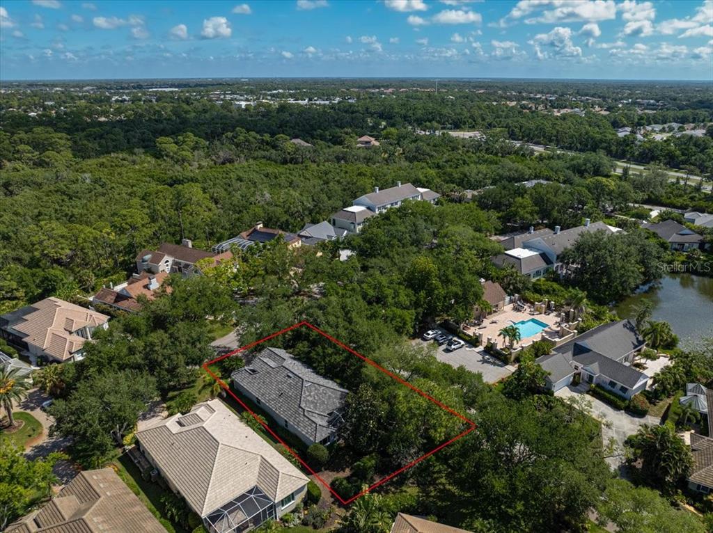 An aerial view shows a single-story house outlined in red surrounded by dense trees — 103 BISHOPS COURT ROAD, OSPREY, FL