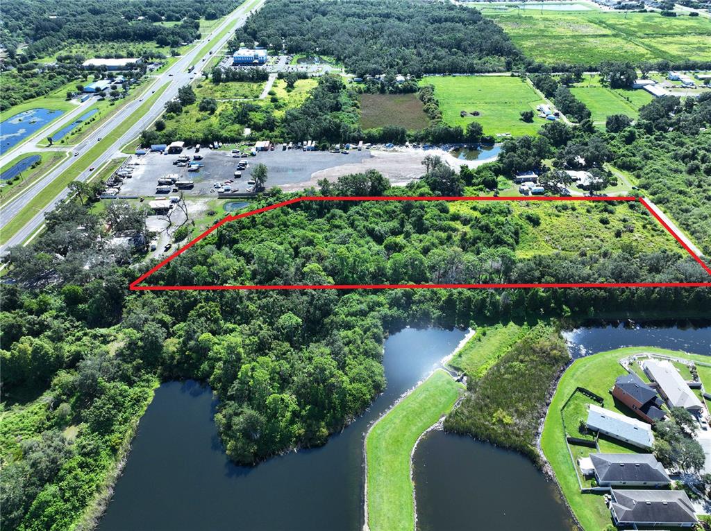 An aerial view shows a rectangular plot of land outlined in red near a highway — 10TH AVE SE, RUSKIN, FL