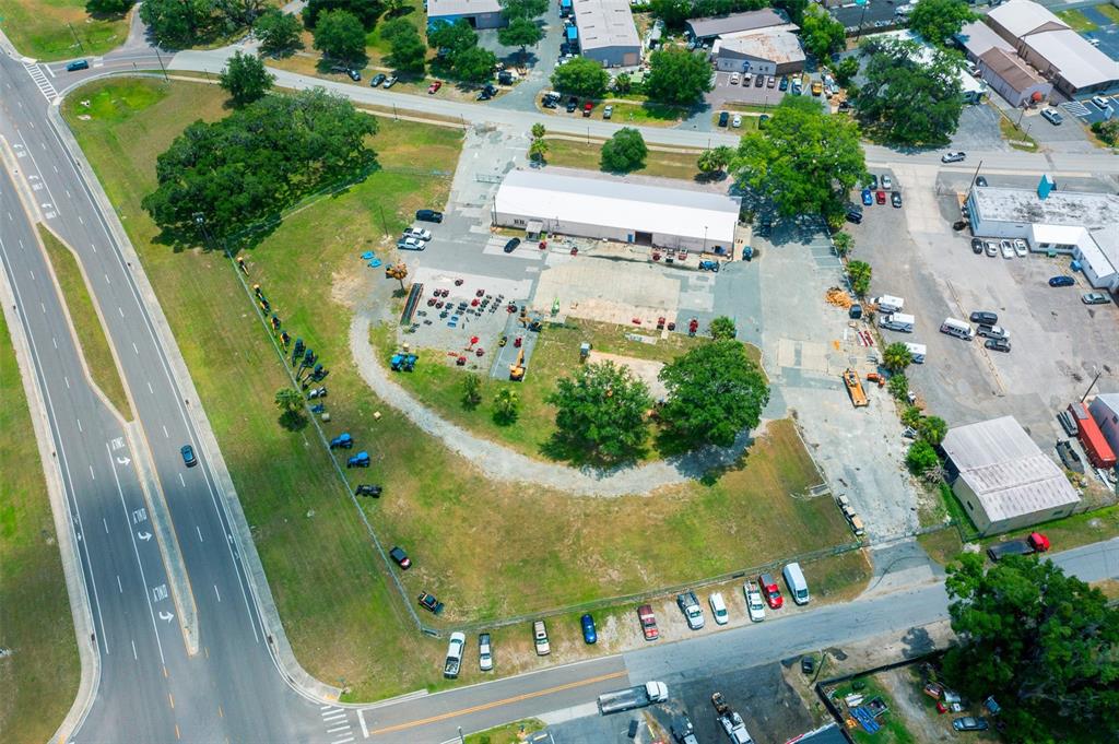An aerial view shows a commercial property with a warehouse, parking lot, and surrounding grounds — 1904 NE JACKSONVILLE ROAD, OCALA, FL