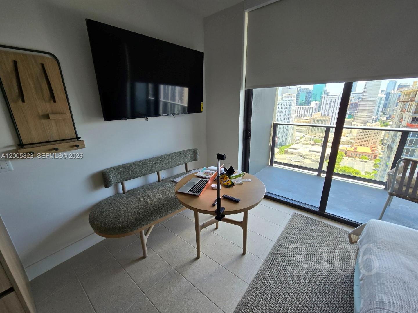 A small dining area features a round table, a bench, and a wall-mounted television — 601 NE 1 Ave # 3406, Miami FL 33132, MIAMI, FL
