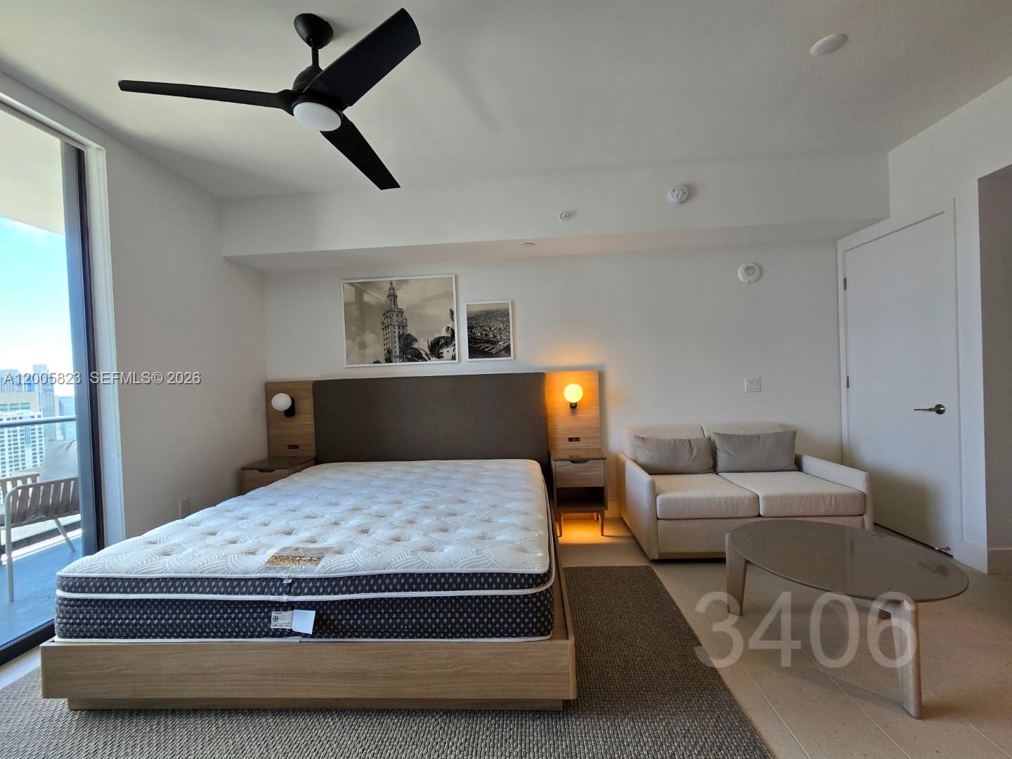 A bedroom features a platform bed, a small sofa, a coffee table, and a balcony — 601 NE 1 Ave # 3406, Miami FL 33132, MIAMI, FL