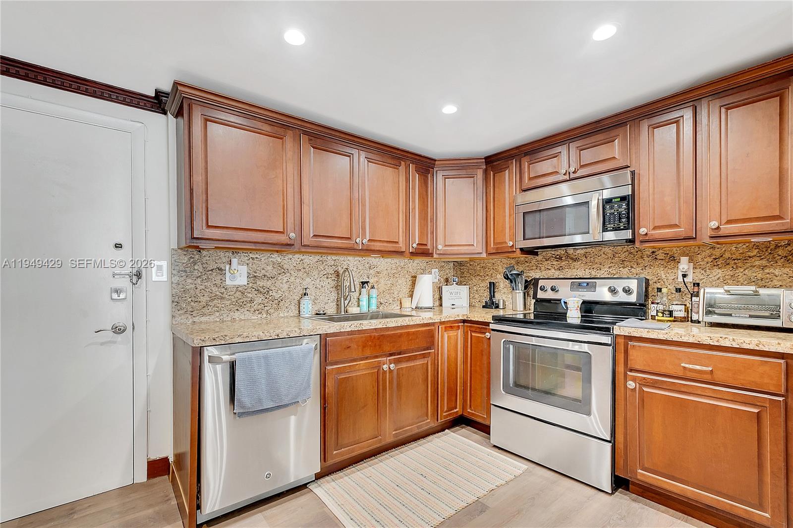 A kitchen features wood cabinets, granite countertops, and stainless steel appliances — 1701 S Ocean Dr # 202, Hollywood FL 33019, HOLLYWOOD, FL