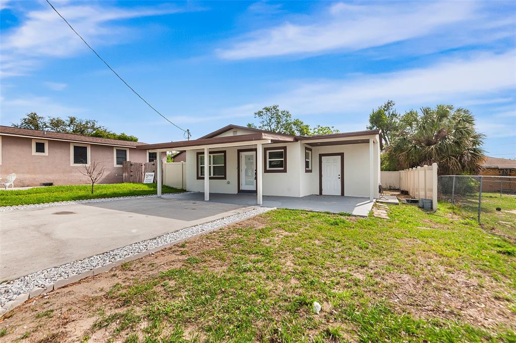 A single-story house with a white exterior, a front carport, and a concrete driveway — 1809 BARTLEY STREET, HAINES CITY, FL