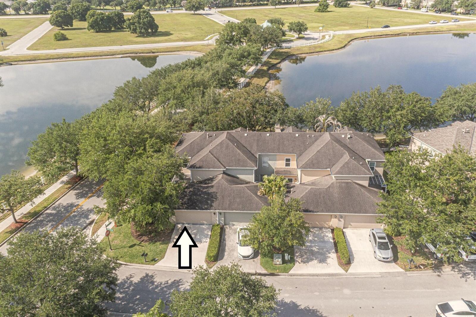 An aerial view shows a multi-unit townhouse with a driveway marked by an arrow — 1838 Pointe West Way, Vero Beach FL 32966, VERO BEACH, FL