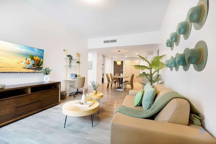 A living room with a beige sofa, wooden media console, round coffee table, and wall-mounted hats — 777 N Ocean Dr # N521, Hollywood FL 33019, HOLLYWOOD, FL