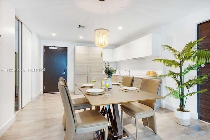 A dining area features a modern table with four chairs, a beaded pendant light, and cabinetry — 777 N Ocean Dr # N521, Hollywood FL 33019, HOLLYWOOD, FL