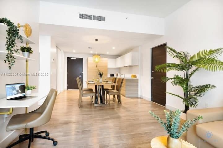 A modern open-concept living area features a home office desk, dining table, and kitchen — 777 N Ocean Dr # N521, Hollywood FL 33019, HOLLYWOOD, FL