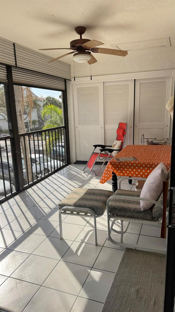 A screened-in balcony features tiled flooring, a ceiling fan, a dining table, and outdoor seating — 5267 Europa Drive, Boynton Beach FL 33437, BOYNTON BEACH, FL