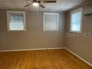 A room with light wood flooring, gray walls, two windows, and a ceiling fan — 912 E SAINT CLAIR STREET, TAMPA, FL