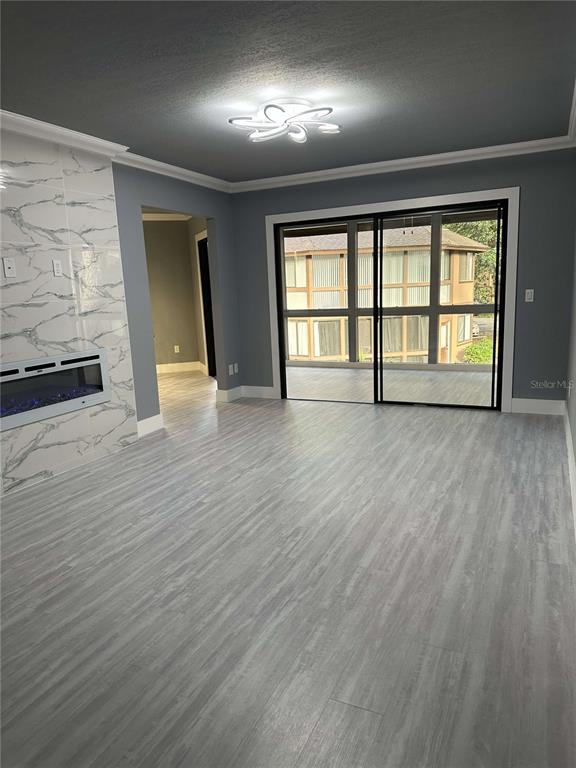 A living room features light wood-look flooring, a marble-tiled fireplace, and sliding glass doors — 14 MID PINES CIRCLE UNIT 14, PALM COAST, FL