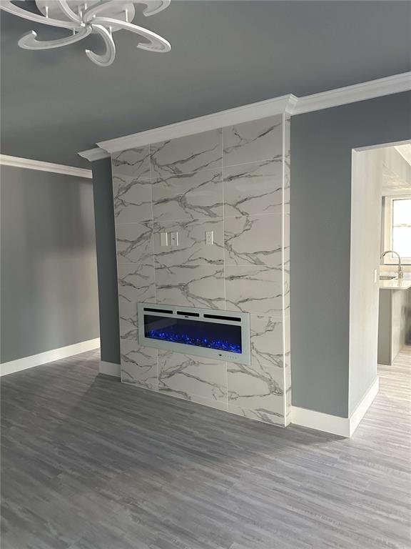 A living room features a marble-tiled fireplace wall with an electric insert and gray flooring — 14 MID PINES CIRCLE UNIT 14, PALM COAST, FL