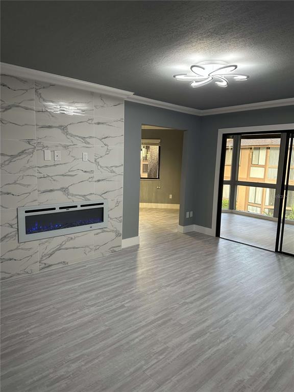 A living room features a marble-tiled fireplace wall, grey flooring, and a modern ceiling light — 14 MID PINES CIRCLE UNIT 14, PALM COAST, FL