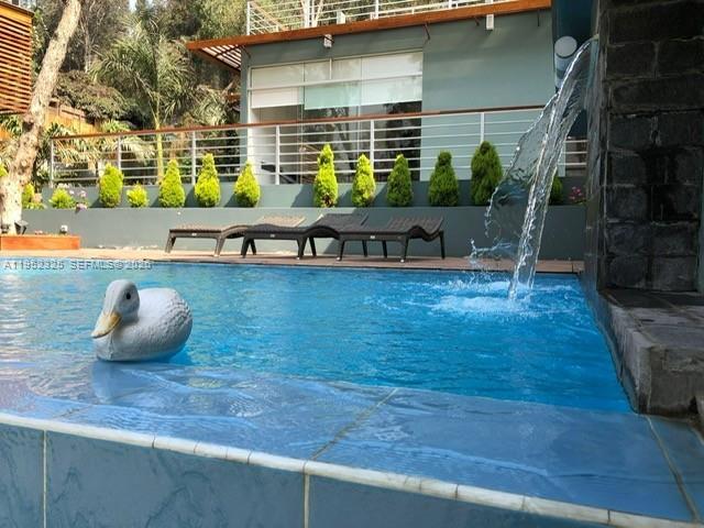A swimming pool with a duck float and a stone water feature sits outdoors — 130 Av. Malecon, California, Chosica, Lima - Peru, FL, FL