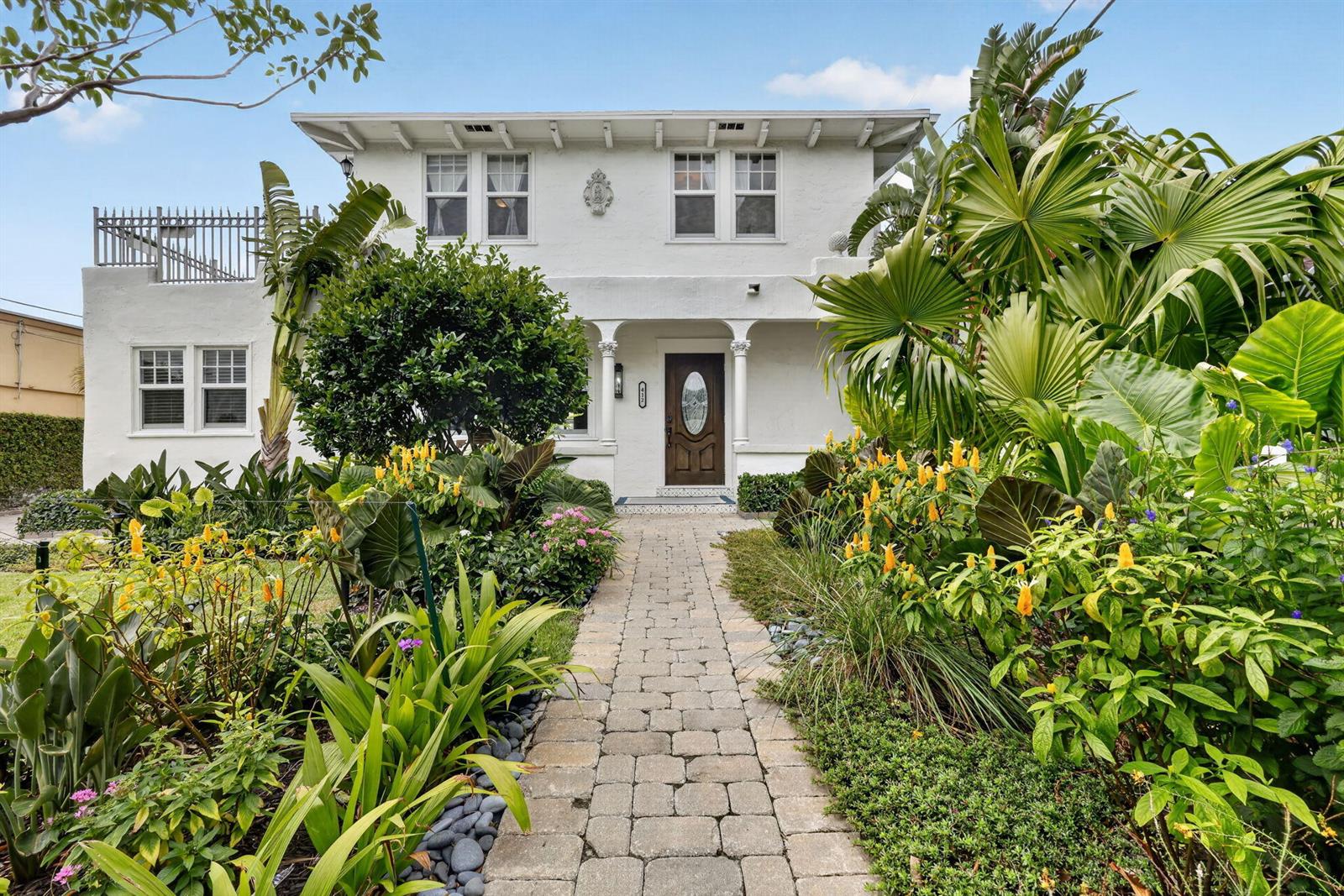 A white two-story house with a stone walkway and lush tropical landscaping in front — 412 El Prado, West Palm Beach FL 33405, WEST PALM BEACH, FL