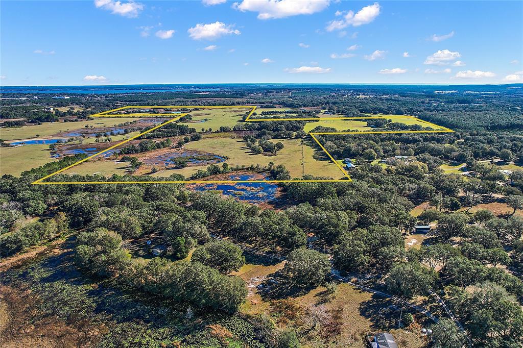 An aerial view shows a large, rural property outlined in yellow with ponds and trees — 0000 SILVERWOOD LANE, HOWEY IN THE HILLS, FL