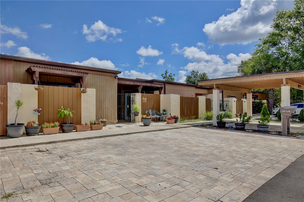 A paved driveway leads to a single-story house with a wooden carport and patio area — 2339 INAGUA WAY, WINTER PARK, FL