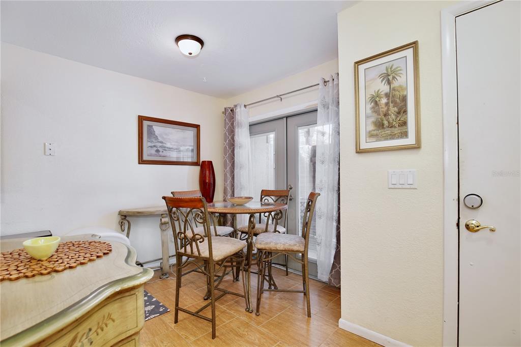 A dining area features a round glass table, metal chairs, tile flooring, and French doors — 2339 INAGUA WAY, WINTER PARK, FL