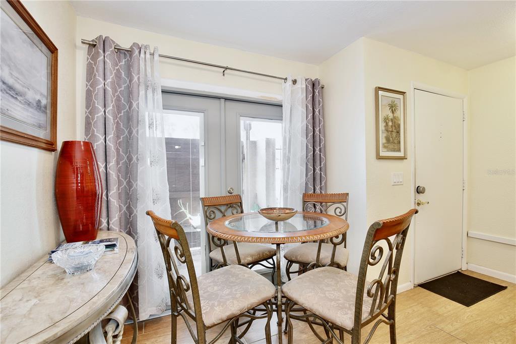 A dining area features a glass-topped table, four metal chairs, and a sliding glass door — 2339 INAGUA WAY, WINTER PARK, FL