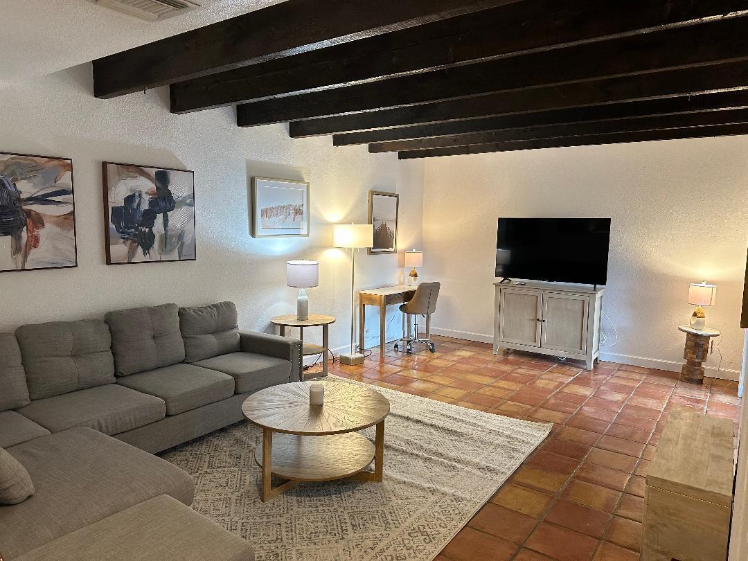 A living room features a gray sectional sofa, a round coffee table, and exposed ceiling beams — 1608 Shaker Circle Circle, Wellington FL 33414, WELLINGTON, FL