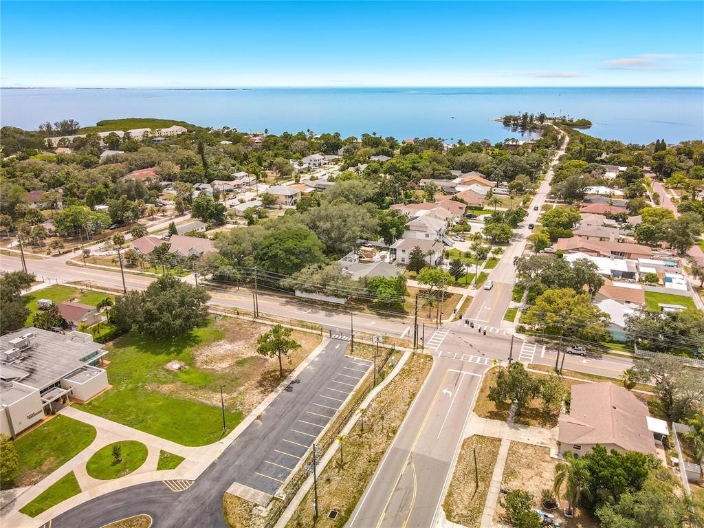 An aerial view shows a coastal neighborhood with houses, roads, and a parking lot — 1601 GULF ROAD, TARPON SPRINGS, FL