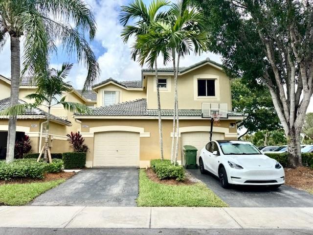 A two-story tan house with a two-car garage and a white car parked outside — 2567 Cordoba Bnd, Weston FL 33327, WESTON, FL