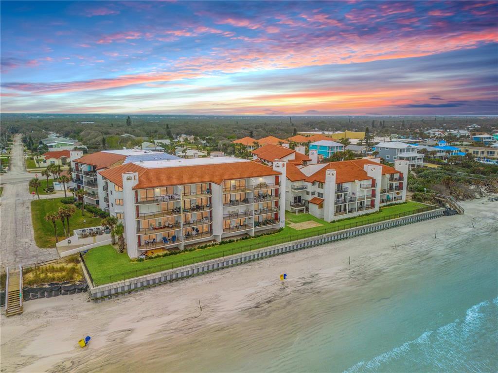 An aerial view of a multi-story beachfront condominium complex with orange tile roofs — 3001 S ATLANTIC AVENUE UNIT 503, NEW SMYRNA BEACH, FL