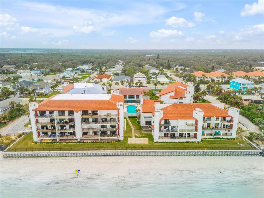 An aerial view of a multi-story beachfront condominium complex with a pool and orange roofs — 3001 S ATLANTIC AVENUE UNIT 503, NEW SMYRNA BEACH, FL