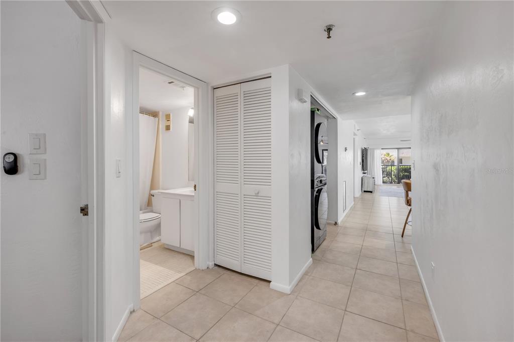 A hallway with tile flooring leads to a bathroom, a laundry closet, and a living area — 3001 S ATLANTIC AVENUE UNIT 503, NEW SMYRNA BEACH, FL