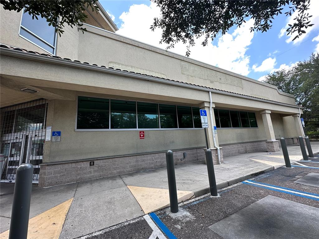 The exterior of a commercial building features a concrete sidewalk, bollards, and accessible parking spaces — 3917 N NEBRASKA AVENUE, TAMPA, FL
