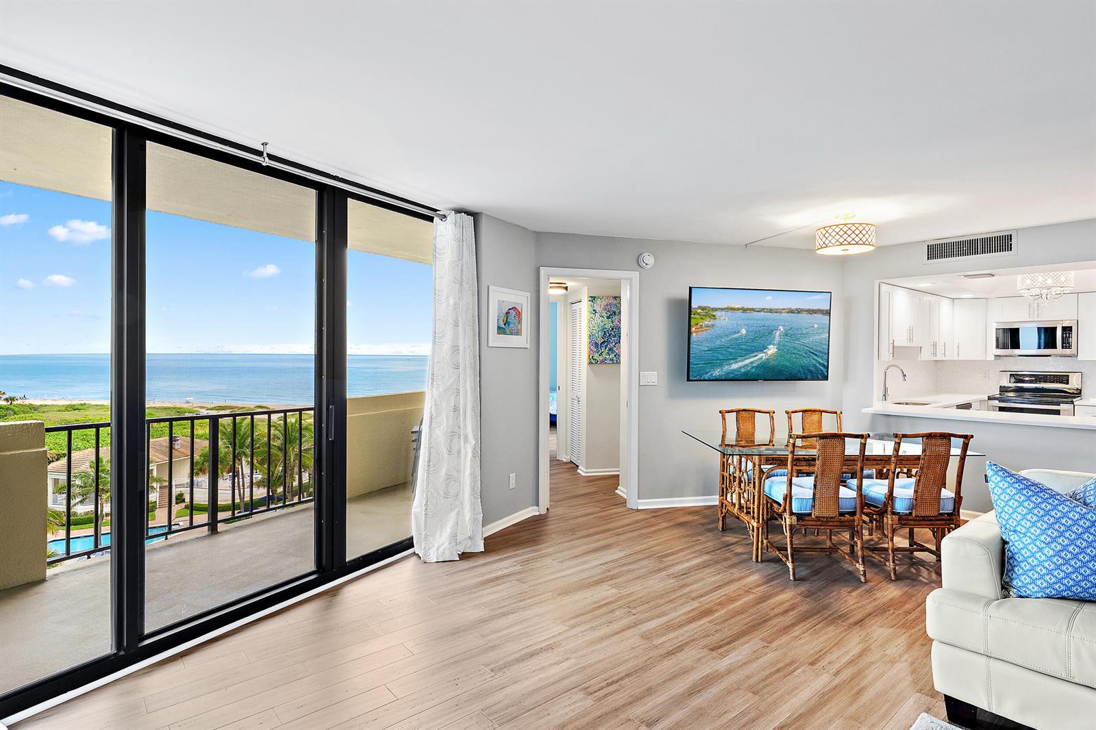 A living and dining area with wood-look flooring, a balcony, and an ocean view — 2800 N Ocean Drive # 7c, Singer Island FL 33404, SINGER ISLAND, FL